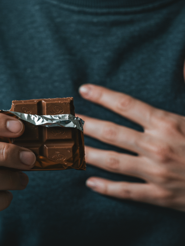 Mãos segurando um doce e tocando o peito, simbolizando a fome emocional e a conexão com as emoções.