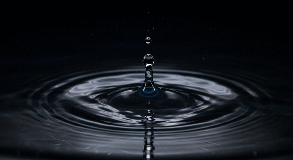 Gota d'água criando ondas luminosas.