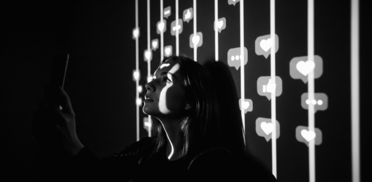 Imagem metaforica em preto e branco de uma pessoa com expressao aprisionada, onde a luz de um celular projeta barras de luz e icones de redes sociais em seu rosto, simbolizando a prisao da validacao d